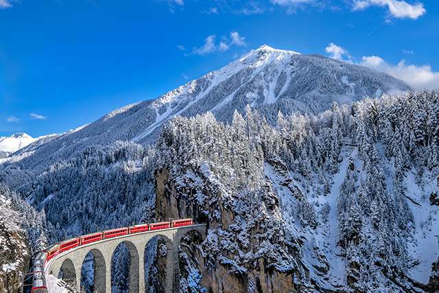 列車駛過宏偉的郎德瓦薩橋（Landwasser Viaduct），經典石造拱橋襯托列車景色。