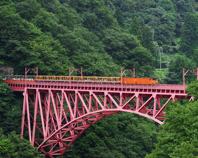 紅色鐵橋「新山彥橋」為宇奈月站著名地標，列車通過時會響起巨大回音，因此得名(山彥的日文發音有山中迴音之意)。